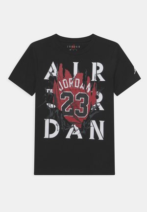 Camiseta negra con letras blancas en negrita "AIR JORDAN", número 23 en rojo y nombre "Jordan" en un gráfico rasgado sobre el pecho.