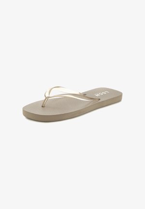 Beige Flip-Flops mit einer strukturierten Sohle, transparenten Riemen und einem dicken gepolsterten Fußbett, das ein dezentes Markenlogo auf der Sohle trägt.