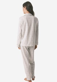 Set di pigiama grigio chiaro con un delicato motivo floreale, maniche lunghe, pantaloni a gamba dritta e rifiniture a contrasto su polsini e colletto.