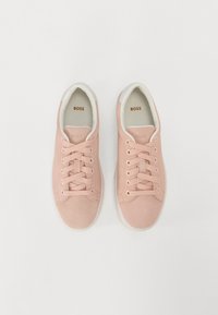 Sneakers in suede rosa con suole in gomma bianche, lacci a sei occhielli, colletto imbottito e logo "BOSS" embossato sulla linguetta e sulla soletta.