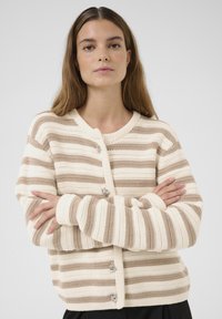 Beige en crèmekleurige gestreepte cardigan met een ronde hals, textuurgebreid en zilveren hartvormige knopen aan de voorkant.