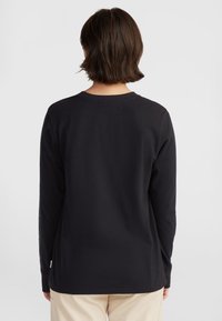 Black long-sleeve t-shirt made of soft cotton. Features a round neckline and a curved hem, with a smooth texture and relaxed fit.