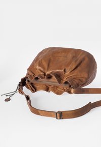 Borsa in pelle marrone con una forma morbida, parte superiore arricciata con chiusura a zip, tracolla regolabile e dettaglio in catena con un'etichetta rotonda.
