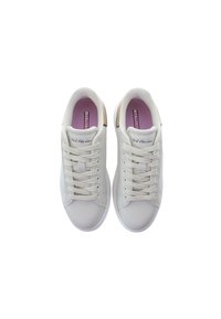 Białe sportowe sneakersy o gładkiej fakturze, okrągłym nosku i beżowych akcentach na pięcie. Widoczne sznurowadła i logo na języku.