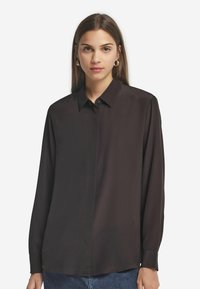Schwarze Bluse mit langen Ärmeln, Kragen, Knopfverschluss und glatter Textur. Verfügt über einen geraden Saum und einen leicht lockeren Schnitt.