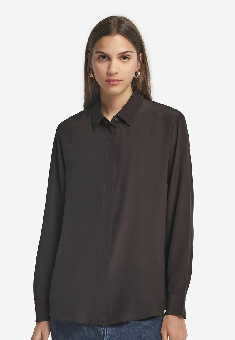 Schwarze Bluse mit langen Ärmeln, Kragen, Knopfverschluss und glatter Textur. Verfügt über einen geraden Saum und einen leicht lockeren Schnitt.