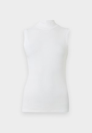 Bež medvilnės marškiniai be rankovių su aptempta forma ir lygiu audiniu, ant šviesaus fono.