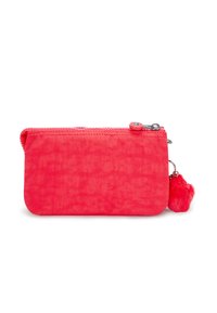 Pink fabric wallet with a textured surface, zip closure, and a fur pompom keychain attached. Compact rectangular shape.