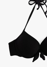 Top bikini nero, tessuto morbido, coppe triangolari, lacci regolabili, lati testurizzati, leggermente imbottito, con un dettaglio a fiocco al centro frontale.