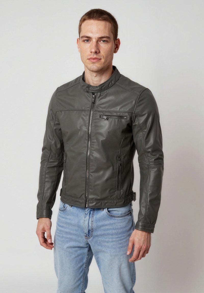 Graue Kunstlederjacke mit hohem Kragen, vorderem Reißverschluss und zwei Seitentaschen. Schlanker Schnitt mit genähten Details.