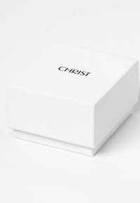 Weißer quadratischer Schmuckkasten mit schwarzem "CHRIST"-Logo, das zentriert auf dem Deckel platziert ist, auf einer weißen Oberfläche.