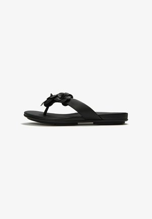 Black flat thong sandal with a wide strap and decorative leather flower on a white background.