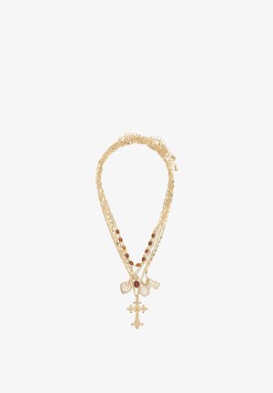 Gelaagde ketting in goudkleur met meerdere kettinkjes, amberkleurige kralen en hangers, waaronder een kruis en decoratieve vormen.