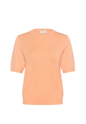 Pulover s kratkimi rokavi in okroglim izrezom, izdelan iz mehkega pletenega materiala breskveve barve z gladko teksturo in diskretnimi rebrastimi detajli na izrezu in robu.