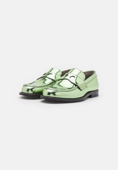 Zaļi patentēta ādas loafers ar gludu, spīdīgu apdari, apaļu purngalu, dekoratīvu joslu un diviem izgriezumiem uz augšdaļas. Melna gumijas zole.