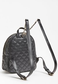 Sac à dos en cuir noir matelassé avec des bretelles réglables doubles, une poignée supérieure, des accents en métal argenté et une poche zippée sur le côté.