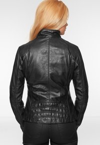 Schwarze Lederjacke mit tailliertem Design, hohem Kragen, gerippten Schulterakzenten und Nahtdetails. Glatte Textur mit klassischem Aussehen.