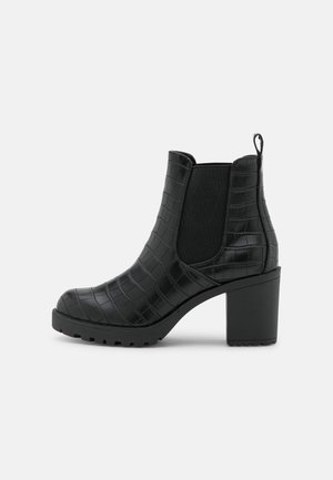 Schwarzer knöchelhoher Stiefel mit Blockabsatz, kroko-geprägtem Leder, elastischen Seitenteilen und Schlaufe auf einfachem hellem Hintergrund.