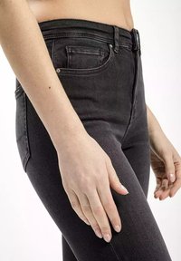 Czarne dżinsy z wysokim stanem, wykonane z denimu, z klasycznym pięciopocketowym wzorem, subtelnym przyszywaniem i zamkiem błyskawicznym z przodu.