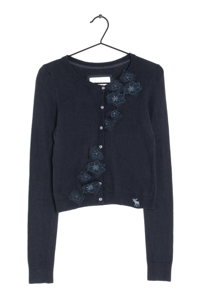 Granatowy kardigan z długimi rękawami, okrągłym dekoltem i zapięciem na guziki. Ozdobiony haftowanymi kwiatowymi akcentami na przodzie oraz małym logo jelenia.