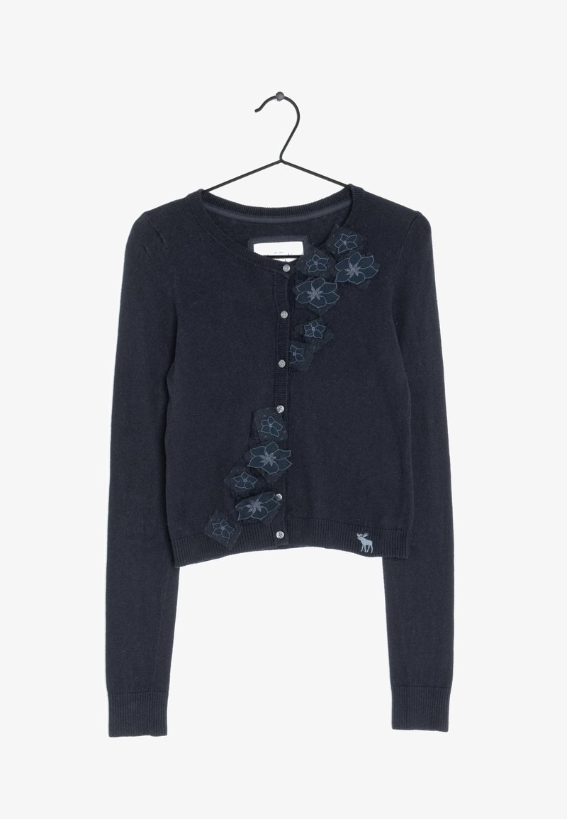 Granatowy kardigan z długimi rękawami, okrągłym dekoltem i zapięciem na guziki. Ozdobiony haftowanymi kwiatowymi akcentami na przodzie oraz małym logo jelenia.
