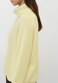 Maglione a collo alto ribbed di colore giallo chiaro con una vestibilità comoda, caratterizzato da maniche lunghe e un motivo a maglia testurizzato.