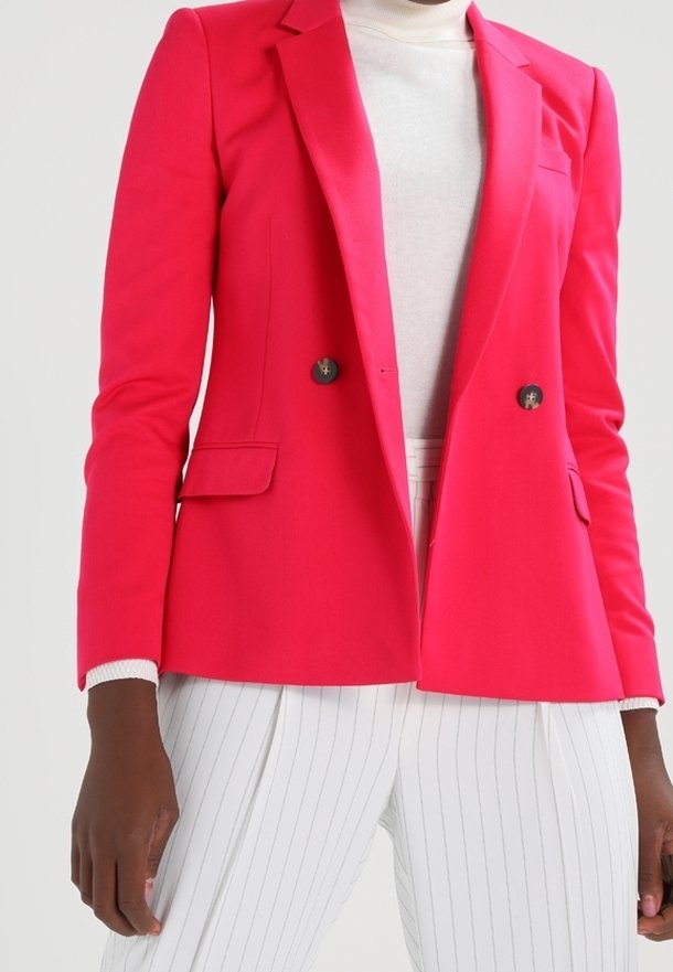 Dvouvrstvý saka fuchsie se zářezovými klopami, dvěma předními kapsami a stříbrnými knoflíky, doplněné bílými kalhotami s proužkem.