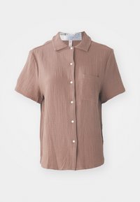Chemise à manches courtes avec boutons en rose poussiéreux, fabriquée en tissu texturé avec une poche. Présente un col classique et cinq boutons sur le devant.
