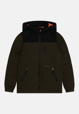 Giacca a vento in verde scuro con spalle nere. Presenta un cappuccio, una cerniera frontale e diverse tasche nere con zip. Foderata in tessuto arancione.