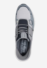 Zapatilla gris tipo slip-on con parte superior de malla, acentos texturizados y collar acolchado. Presenta cordones elásticos y plantilla acolchada etiquetada como "Skechers Slip-Ins."