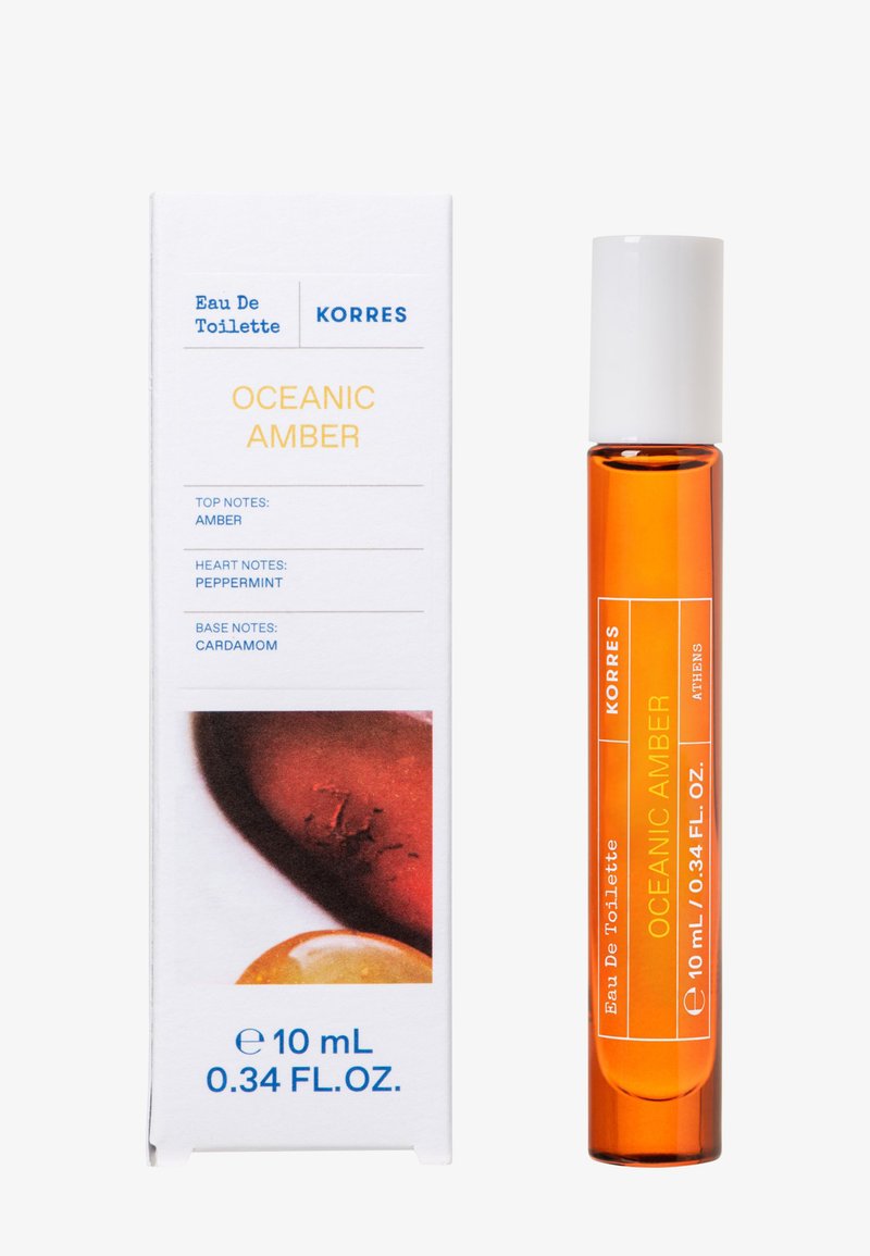 Korres Oceanic Amber Eau de Toilette 10 ml flacon en verre ambré avec bouchon blanc à côté d'une boîte blanche listant les notes : ambre, menthe poivrée, cardamome.