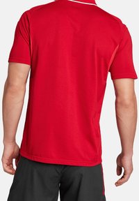 Czerwona koszulka sportowa krótki rękaw o gładkiej fakturze, z okrągłym dekoltem i białym akcentem wzdłuż kołnierza.