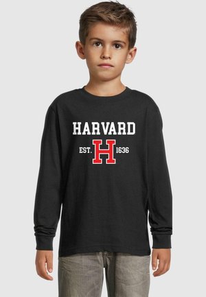 Schwarzes Langarmshirt mit dem Schriftzug "HARVARD EST. 1636" in fetten weißen und roten Buchstaben, ergänzt durch ein großes rotes "H". Weicher Stoff.
