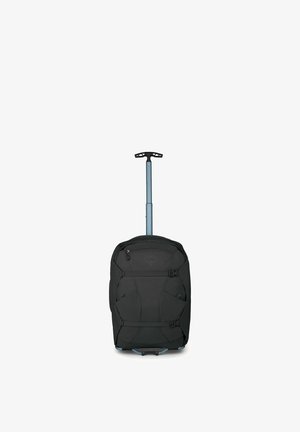 Sac de sport noir à roulettes avec poignée télescopique étendue et sangles de compression à l'avant, debout sur fond blanc.