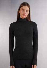 Sort turtleneck-top i et blødt, tekstureret stof, der har lange ærmer og en tætsiddende silhuet med subtile farveflekker.