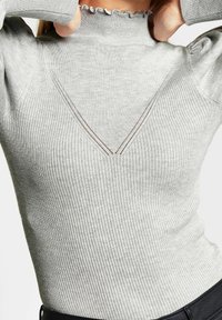 Grå ribbad höghalsskjorta med djup V-formad utskärning, eleganta scalloped kanter och detaljerad sömnad. Mjuk, texturerad tyg.
