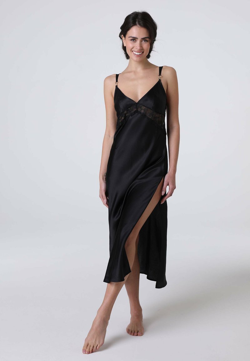 Vestito da notte in raso nero con dettagli in pizzo, scollatura a V profonda, spalline regolabili e uno spacco fino alla coscia, creando una silhouette elegante.