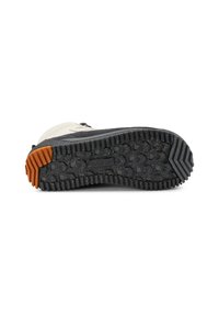 Suela de zapato negra con tacos, con un agarre naranja en el talón y textura salpicada, unida a una bota de senderismo beige y negra.