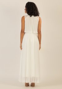 Witte geplooide maxi-jurk met een doorzichtige, gedrapeerde rug. De stof is lichtgewicht met een gladde textuur, aangevuld met een aansluitende tailleband.
