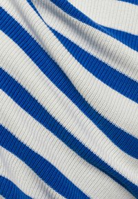 Blauw en wit gestreepte stof met een gestructureerd, geribbeld patroon. De strepen wisselen af tussen dikke blauwe en dunne witte.