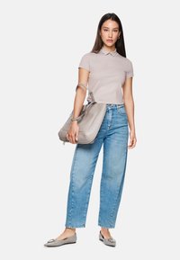 Light gray polo shirt with a collar, paired with loose-fit blue jeans. Holding a large gray handbag, wearing gray flats with a square accent.