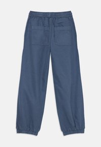 Navy blue casual pants with elastic waistband and ankle cuffs, featuring two large rear patch pockets, one with a small heart detail.