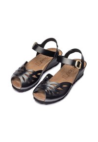 Sandales noires avec un design découpé en forme de feuille, bride de cheville avec boucle, semelle en liège et semelle texturée pour une bonne adhérence. Bout fermé et design ouvert.