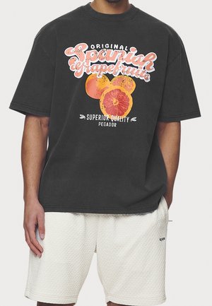 Black cotton t-shirt featuring a large graphic print of sliced grapefruit and the text "Original Spanish Grapefruit" in colorful lettering.