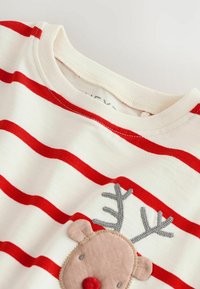 Camicia di cotone bianca con strisce orizzontali rosse, caratterizzata da un'applicazione di renna marrone con corna grigie e un naso rosso sulla parte anteriore.