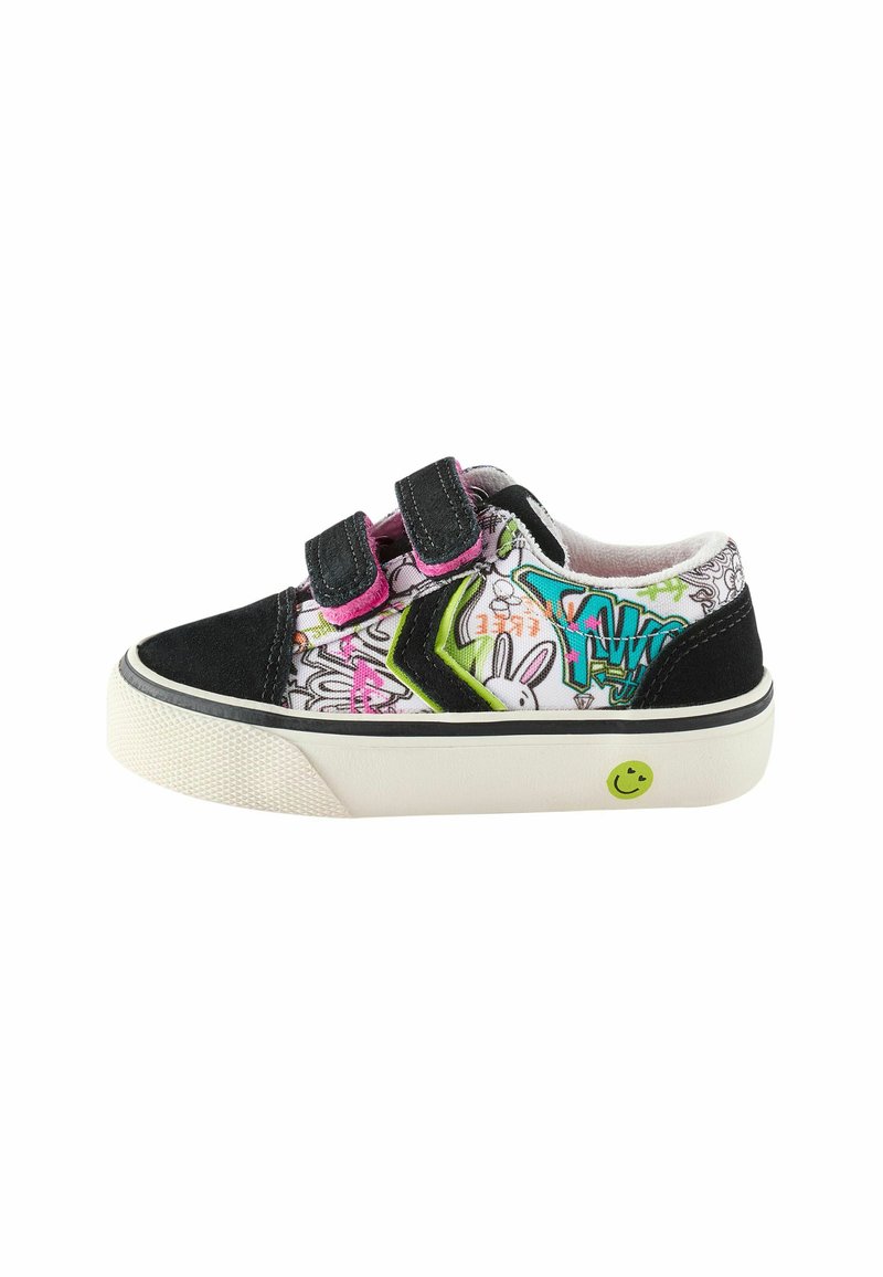 Velcro sneakers med en sort ruskind tå og hæl, farverigt graffiti-design på lærred, hvid gummisål og grøn smiley ansigt detalje.