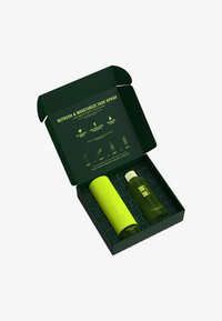 Green rectangular box with a dark green inner lining, containing a bright yellow textured cylinder and a dark green spray bottle.