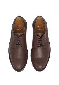 Hnědé kožené boty s hladkým povrchem, kulatou špičkou a šněrováním. Pevná gumová podrážka s jemnými švy.