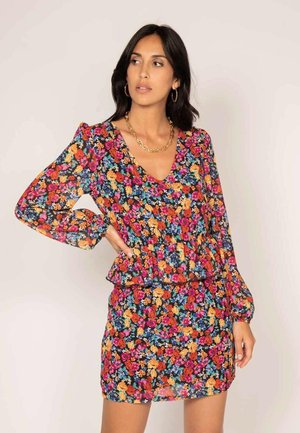 Robe florale avec un décolleté en V, de longues manches bouffantes et une taille peplum. Fabriquée en tissu léger et transparent avec un motif floral multicolore.