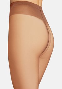 Collant trasparenti color carne con vita alta e morbido elastico. Le cuciture ridotte e la finitura traslucida esaltano l'aspetto naturale delle gambe.